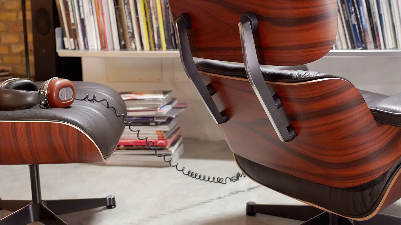 Der Vitra Eames Chair mit Ottoman auf dem Kopfhörer liegen in einem Wohnzimmer