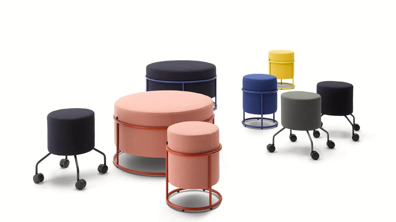 Mehrere Drop Hocker von COR in unterschiedlichen Farben und Größen, teils mit Rollen, teils mit stabilem Rundrahmen – ideal für flexible und stilvolle Arbeitsumgebungen.