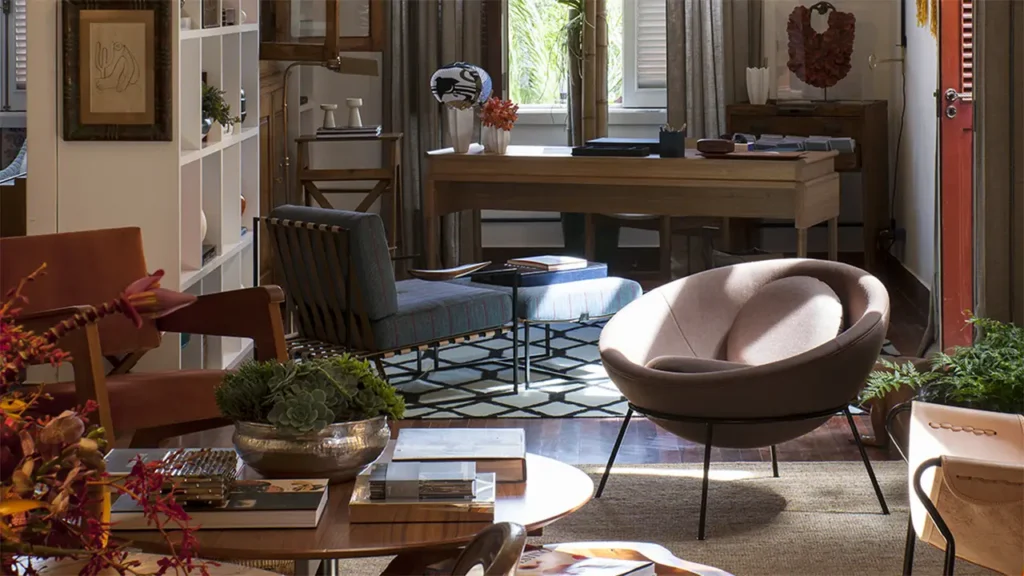 Ein Bardi’s Bowl Chair von Arper in einem wohnlich eingerichteten Raum mit Schreibtisch, Regalen und Sesseln – modernes Design kombiniert mit gemütlicher Atmosphäre.