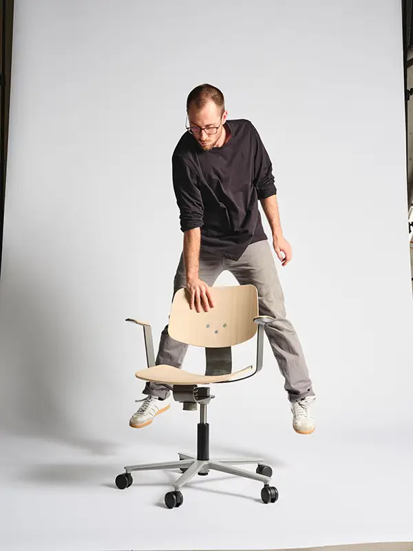 Wilkhahn WiChair – Stabilität und Beweglichkeit im perfekten Gleichgewicht Person testet die flexible Konstruktion des Wilkhahn WiChair durch eine dynamische Bewegung – der Stuhl bleibt stabil und beweglich zugleich.