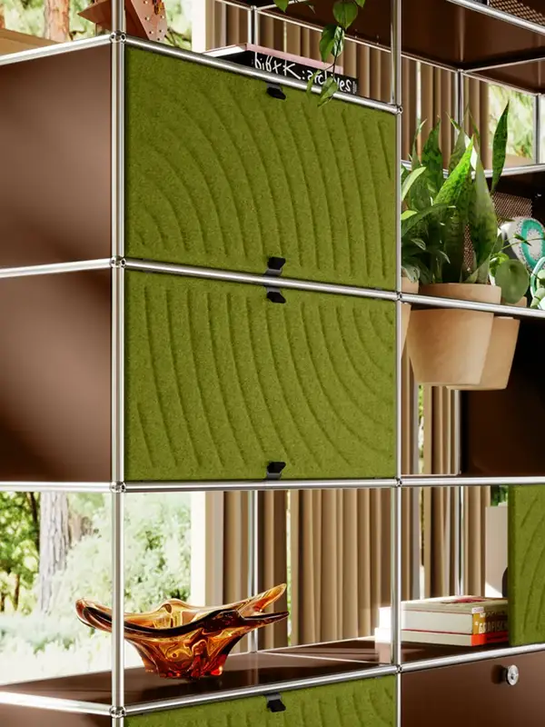 USM Haller Regal mit grünem Soft Panel als textile Akustikfläche, kombiniert mit Pflanzen und offenen Regalfächern